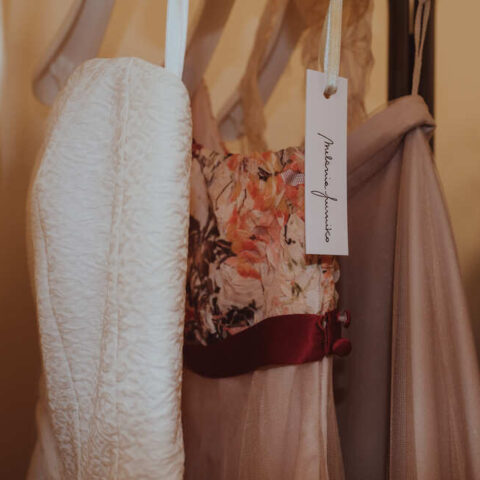 a few designers' clothes hanging on a rack
